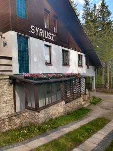 a building with flowers on the side of it at Pensjonat Syriusz in Karpacz