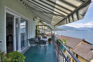 einen Balkon mit einem Tisch und Stühlen auf dem Wasser in der Unterkunft Appartamenti Ramarro in Ronco sopra Ascona