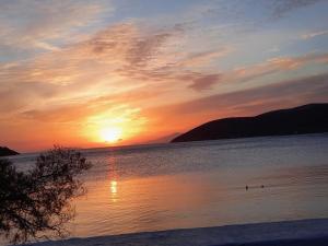 a sunset over a lake with the sun setting at Pension Barbara in Katapola