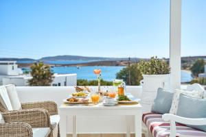 a white table with food and drinks on a balcony at Stelia Mare Boutique Hotel in Naousa