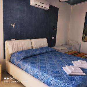 a bedroom with a blue bed with towels on it at Antico Centro Quartu B&B in Quartu SantʼElena