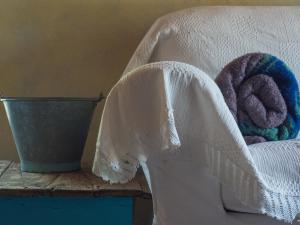 uma cama com um cobertor branco e dois donuts em Vintage Stone-built Country Cottage in Richea em Koulouraíika