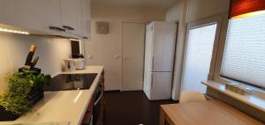 cocina con nevera blanca y ventana en Aia apartement en Kuressaare