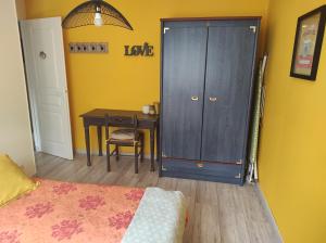 een slaapkamer met een bureau en een deur met een tafel bij appartement Anna in Parentis-en-Born