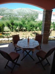 a table and chairs on a patio with a view at Apartmani Peko in Pag