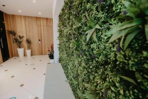 a lobby with a green wall with plants at Hai Hotel in Larnaca