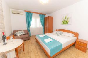sypialnia z łóżkiem, stołem i kanapą w obiekcie Guest House S-Lux w Petrovacu na Moru
