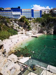 een strand met mensen in het water en gebouwen bij Apartment Mihael in Dubrovnik