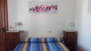 a bedroom with a bed and two dressers and pink flowers at Agriturismo SoleMare in Stromboli