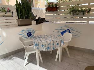una mesa y sillas en una habitación con plantas en Monolocale “Andromeda” a due passi dalla Guitgia, en Lampedusa