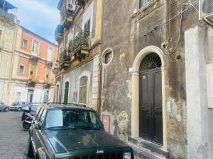 una macchina nera parcheggiata di fronte a un edificio di La casa di Palma a Catania