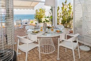 a dining room with a table and chairs and the ocean at Relais Maresca Luxury Small Hotel & Terrace Restaurant in Capri