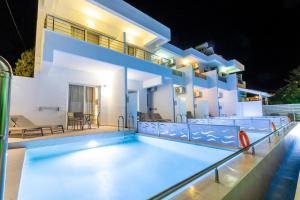 a villa with a swimming pool at night at Stay Helios in Faliraki