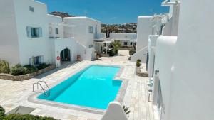 a villa with a swimming pool and white buildings at BLUE DAISY House, Ornos, by MyconBay Mykonos in Ornos