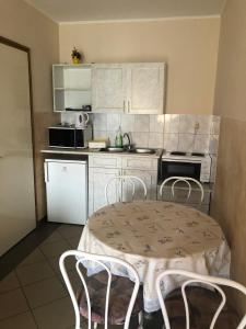 kuchnia ze stołem i krzesłami w kuchni w obiekcie Imre Apartman w Hajduszoboszlo