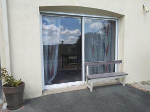 un banco sentado frente a una ventana en Un Petit Coin de Vendé, en La Flocellière