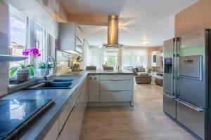 a kitchen with stainless steel appliances and a living room at Family Heritage in Crikvenica