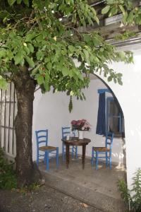 a table and chairs and a tree in a courtyard at Vintage 2 Ferienwohnung für 2-3-4 in Schörfling