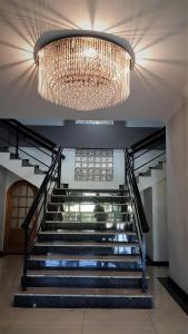 einen großen Kronleuchter und eine Treppe in einem Gebäude in der Unterkunft Hotel Cristal Rio Claro in Rio Claro