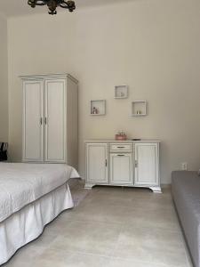 a bedroom with two beds and a white cabinet at SenoRita2 Magánszállás in Miskolc