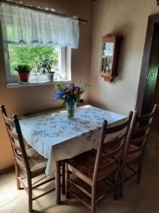 una mesa de comedor con un jarrón de flores. en U Chalupy na Kopečku, en Krásná Lípa
