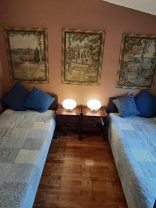 2 camas en una habitación con 2 lámparas en la pared en U Chalupy na Kopečku, en Krásná Lípa