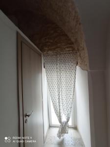 Una ventana en una habitación con una cortina. en Maison Matilde, en Ceglie Messapica
