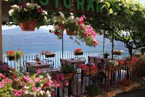 a restaurant with tables with flowers and a view of the water at Hotel Castel Gandolfo in Castel Gandolfo