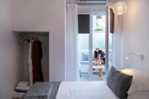a woman is standing in a bedroom with a bed at Acropolis in Parikia