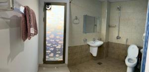 y baño con aseo, ducha y lavamanos. en • Faizi Furnished Apartments, en Faisalabad