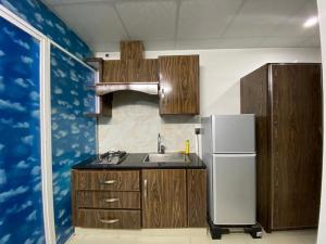 a kitchen with a sink and a refrigerator at • Faizi Furnished Apartments in Faisalabad