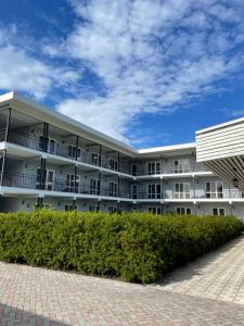 a large white building with bushes in front of it at Hotel Mandarin in Pizunda