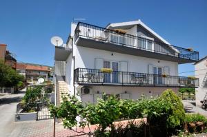 um edifício branco com varandas numa rua em Apartments Roza em Trogir