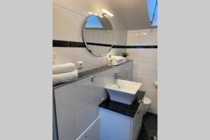 uma casa de banho com um lavatório e um espelho em Ferienwohnung Stang em Dietramszell