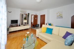 a living room with a white couch and a glass table at Apartments Roza in Trogir