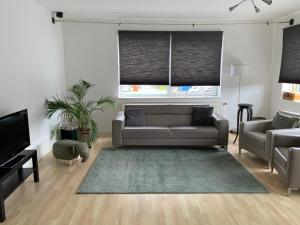 uma sala de estar com um sofá e uma televisão em Apartments Zaanse Schans and Amsterdam em Wormer