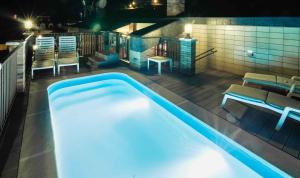- une piscine de nuit avec des chaises et une table dans l'établissement Hotel Dos Rios Origen, à Aínsa