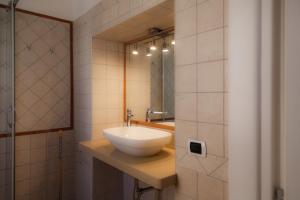 a bathroom with a white sink and a mirror at Donna Lea in Cittadella del Capo +36 photos