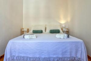 a white bed with two towels on top of it at La finestra sul teatro in Alghero