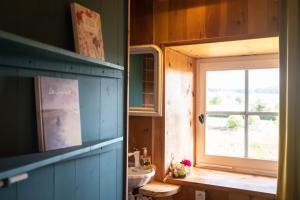 ein Bad mit einem Waschbecken und einem Fenster in der Unterkunft Le Flambeau in Le Bouchet-Saint-Nicolas