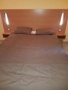 a large bed with two pillows on top of it at Zonnig Appartement Golf van Durbuy in Durbuy