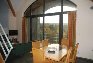 ein Esszimmer mit einem Tisch und einem großen Fenster in der Unterkunft Zonnig Appartement Golf van Durbuy in Durbuy