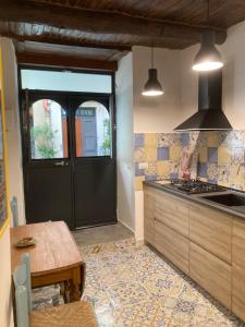 una cucina con porta nera e tavolo di Zuccarella ''Zuccherino''nel cortile a Napoli