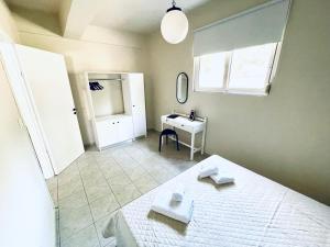 卡拉馬塔的住宿－Sofi's Apartments，卧室配有白色的床和书桌
