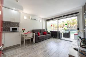une cuisine et un salon avec un canapé et une table dans l'établissement Luxury apt 1 MINUTE from the Beach of the Dunes, à Playa del Ingles