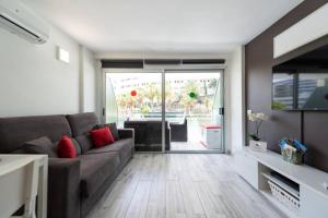 un salon avec un canapé et une porte coulissante en verre dans l'établissement Luxury apt 1 MINUTE from the Beach of the Dunes, à Playa del Ingles