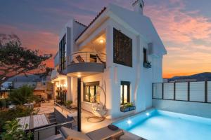 Villa con piscina al atardecer en Paradisos luxury villas next to beach, en Koutsourás