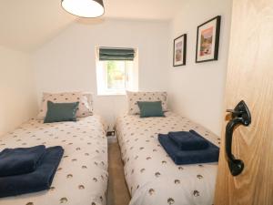 a bedroom with two beds with blue pillows at Ivy Cottage in Matlock