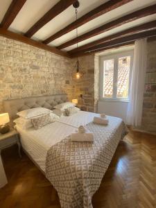 a bedroom with a bed with two towels on it at Palace Wall Residences in Split