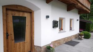 une maison avec une porte en bois et un mur en pierre dans l'établissement Landhaus Eberler, à Mayrhofen